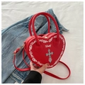 Dettaglio ravvicinato della borsa rossa a cuore con croce gotica e cerniera in metallo d'oro - Rosso