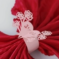Pink laser cut paper napkin ring with rose and heart design on a red silk napkin - Pink