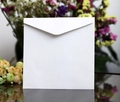 Detailed view of a white square wedding envelope with a triangular flap on a floral background - European White Square