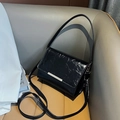 Minimalist black glossy pleated shoulder bag with sleek silver hardware and crossbody strap - Black