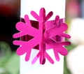 Macro detail of a laser-cut pink metallic snowflake napkin ring for festive table decor - Reflective Rose Red