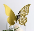 Détail du papillon 3D doré avec motif découpé au laser sur le bord d'un verre - Or Réfléchissant