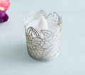Dettaglio ravvicinato di candela LED con paralume in carta traforata a motivi floreali e foglie - Bianco Argento Perlato