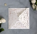 Elegant white laser cut wedding invitation with lace pattern on grey textured background - White