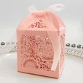 Hollow laser-cut light pink favor box with floral patterns and a white silk ribbon bow - Pink