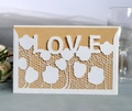 Detail of laser cut white lace invitation with LOVE lettering and kraft paper insert - White