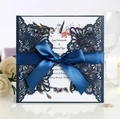 Elegant navy blue laser-cut invitation card with intricate lace pattern and blue ribbon - Ink Blue