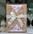 Detail der lasergeschnittenen Hochzeitseinladung in Champagner gold mit Satin Schleife - Beige Gold