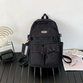 Mochila minimalista de nailon negro con múltiples bolsillos y colgante de cinta decorativo - Negro