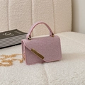 Mini square handbag in shiny purple glitter fabric with gold chain strap on white sofa - Pink