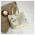 Dettaglio della borsa tote in tela crema con tasca laterale e piccolo portamonete fashion - Bianco