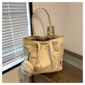 Dettaglio della borsa tote in tela crema con il borsellino rotondo coordinato e il logo - Cachi