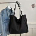 Minimalist large capacity black canvas tote bag for women shown hanging in a home setting - Black