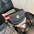 Matte black saddle crossbody bag with a golden turn-lock and decorative silk scarf wrap - Black