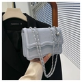 Close-up of light blue velvet bag with wave flap, silver chain, and metal ball charm - Blue