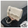 Chic off-white suede crossbody bag with wave flap design and silver chain strap - White