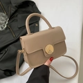 Chic beige crossbody bag with a circular gold buckle and elegant top handle - Khaki