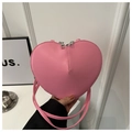 Close-up of pink heart-shaped bag with dual silver zippers and textured leather - Pink