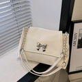 Creamy white leather shoulder bag with a silver metal bow accent and chain strap - White
