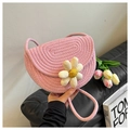 Detailed close-up of a pink woven cotton shoulder bag featuring a cute smiling daisy charm - Pink
