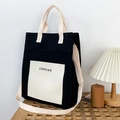 Minimalistische schwarze Canvas-Tragetasche mit cremefarbener Tasche und Doppelriemen - Schwarz und Weiß