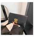 Detail der schwarzen Clutch mit Krokoprägung und goldenem geometrischem Metallverschluss - Schwarz