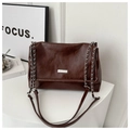Close-up of dark brown PU leather texture and silver chain strap on a tote bag - Coffee