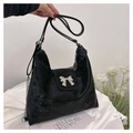 Close-up of black velvet tote bag featuring a silver metal bow detail and zipper closure - Black