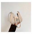 Detail of cream white half-moon bag featuring a large silver petal-shaped metal buckle - Khaki