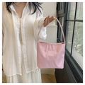 Rosafarbene Nylon-Tragetasche mit weißer Stickerei und feinem Griff in Lifestyle-Atmosphäre - Rosa