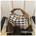 Detail der karierten Web-Tasche mit braunem Raffgriff und herzförmigem Anhänger - Weiß