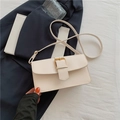 Bolso bandolera rectangular beige con hebilla dorada sobre traje azul elegante - Blanco Roto