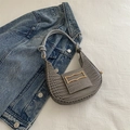 Sac hobo gris texture crocodile avec boucle dorée et anse torsadée sur fond en jean - Gris