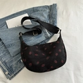 Black corduroy half-moon bag featuring a vibrant red strawberry print and wide strap - Black