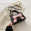 Classic black handbag with pink bow decoration, adjustable shoulder strap and round handle - Black & Pink