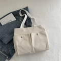 Minimalistische beige Canvas-Einkaufstasche mit großen Fronttaschen und weißen Tragegriffen - Weiß