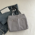 Graue Segeltuchtasche mit zwei Vordertaschen und silbernen Metallnieten - Grau