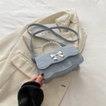 Light blue bow-knot crossbody bag with pearl handle and marble texture detail - Blue