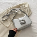 Silver crescent shoulder bag featuring a luxury rhinestone buckle and metallic leather - Silver