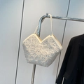 Chique beige jacquard draagtas met franjes en V-vormige opening aan een metalen rek - Wit