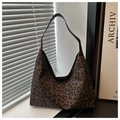 Detail van vintage hobo tas met luipaardprint en zwarte lederen schouderband textuur - Donkerbruin