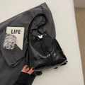 Borsa a secchiello in pelle nera lucida con ciondolo a farfalla e chiusura a coulisse - Nero