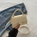Borsa a tracolla minimalista in pelle beige con fibbia cilindrica su letto bianco - Giallo
