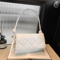 White quilted underarm bag with unique knotted strap and elegant gold metal accents - White
