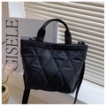 Chic black quilted bucket bag with adjustable shoulder strap near elegant tulips - Black