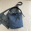 Sac seau en denim bleu avec lanières en cuir noir et nœud papillon, vue à plat de haut - Bleu foncé