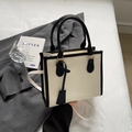 Elegante bolso tote crema con bordes negros en contraste y correa ajustable para hombro - Blanco Roto