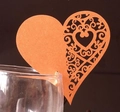 Close-up of laser-cut heart shaped orange place cards on the rim of a wine glass - Antique Bronze