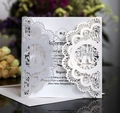 Gros plan de l'invitation de mariage découpée au laser avec dentelle florale et oiseaux - Blanc