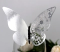 Macro view of silver laser-cut butterfly cup card with intricate floral lace texture - Reflective Silver